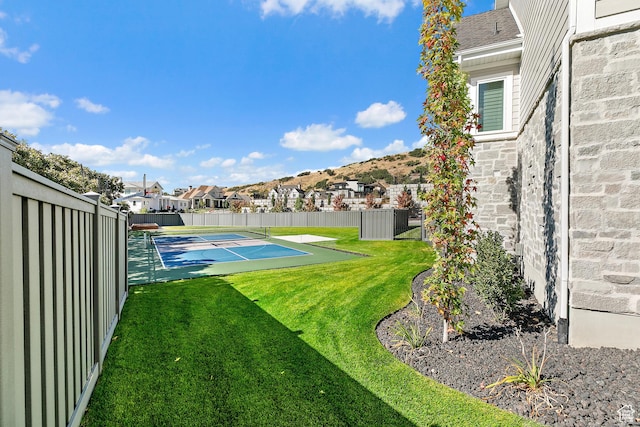 view of yard with shuffleboard, fence, and a residential view