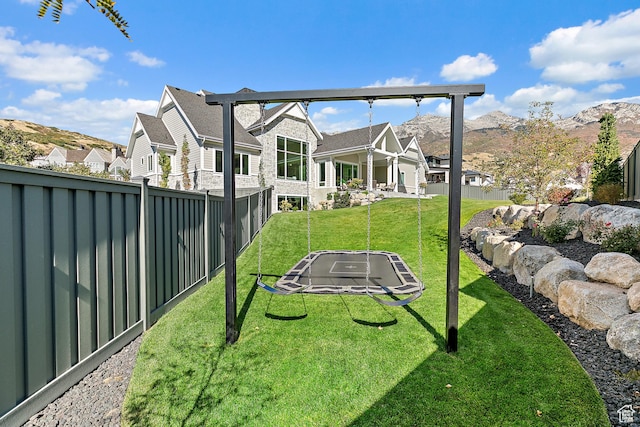 view of yard with a fenced backyard, a mountain view, and a residential view