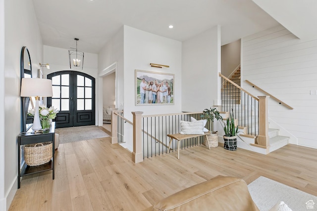 entryway featuring recessed lighting, a notable chandelier, wood finished floors, and stairs
