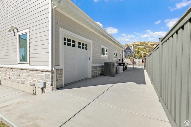 garage featuring central AC unit and fence
