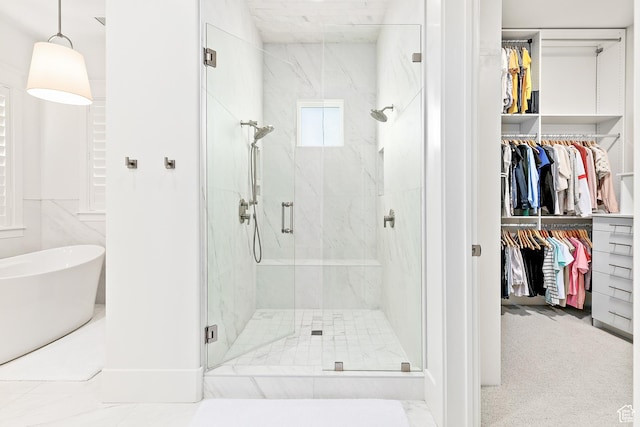 bathroom featuring a marble finish shower and a walk in closet