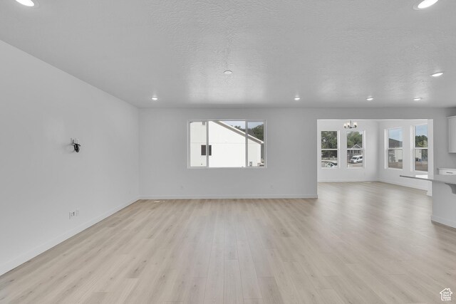 1811 N 375 W Unit 8, Harrisville, UT 84404 - unfurnished living room featuring recessed lighting, light wood-style floors, a chandelier, and a textured ceiling