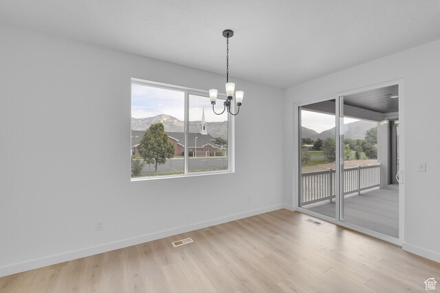 406 W 1225 N Unit 4, Harrisville, UT 84404 - unfurnished dining area with a mountain view, a chandelier, wood finished floors, and plenty of natural light