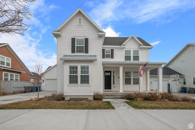 traditional-style house with a garage, roof with shingles, covered porch, and driveway