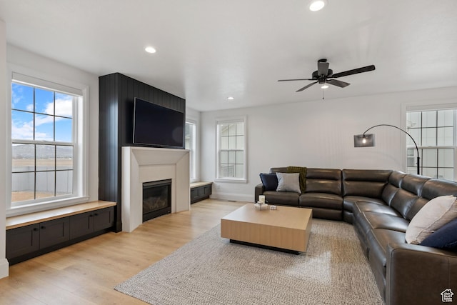 238 W Founders Blvd, Saratoga Springs, UT 84045 - living room with light wood-style flooring, a glass covered fireplace, recessed lighting, baseboards, and ceiling fan