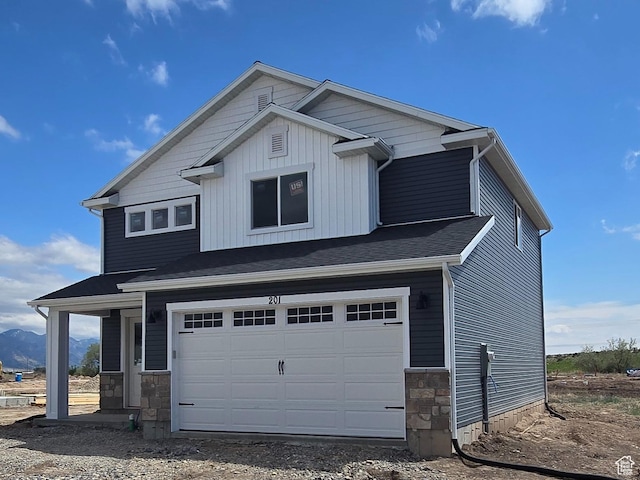 view of front of property featuring dirt driveway, stone siding, and an attached garage