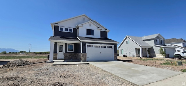 201 W 1300 S Unit 32, Tremonton, UT 84337 - view of front facade featuring driveway, a garage, and stone siding
