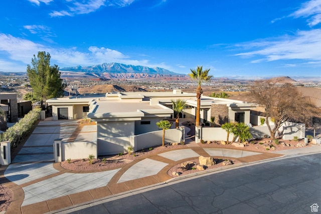 2031 E Cliff Point Dr, St George, UT 84790 - view of front of house with a mountain view, a fenced front yard, concrete driveway, and stucco siding