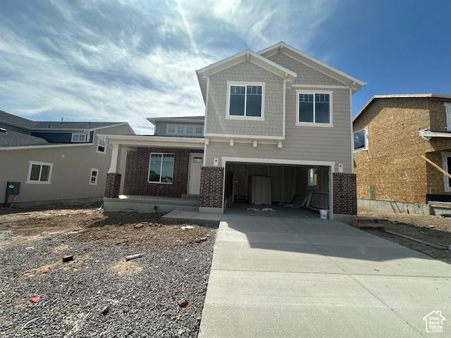 6327 W Butte County Dr S Unit 446, Herriman, UT 84096 - craftsman house featuring a garage, covered porch, concrete driveway, and brick siding