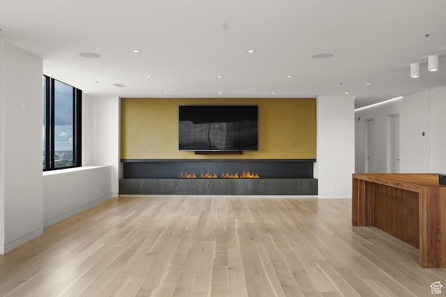 48 W 300 S Unit 2204-N, Salt Lake City, UT 84101 - unfurnished living room with recessed lighting, a warm lit fireplace, light wood-type flooring, and baseboards