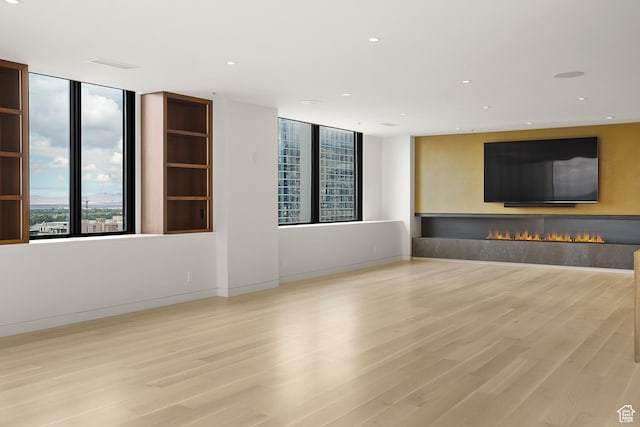48 W 300 S Unit 2204-N, Salt Lake City, UT 84101 - unfurnished living room with recessed lighting, wood finished floors, baseboards, and a warm lit fireplace