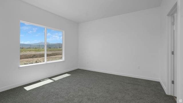 6311 W Butte County Dr S Unit 448, Herriman, UT 84096 - empty room featuring a mountain view, dark colored carpet, and baseboards