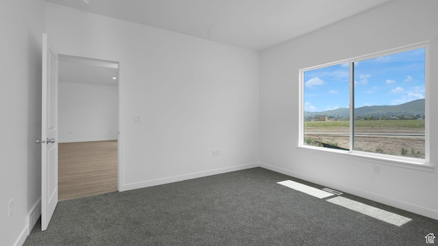 6311 W Butte County Dr S Unit 448, Herriman, UT 84096 - empty room with dark carpet, a mountain view, and baseboards