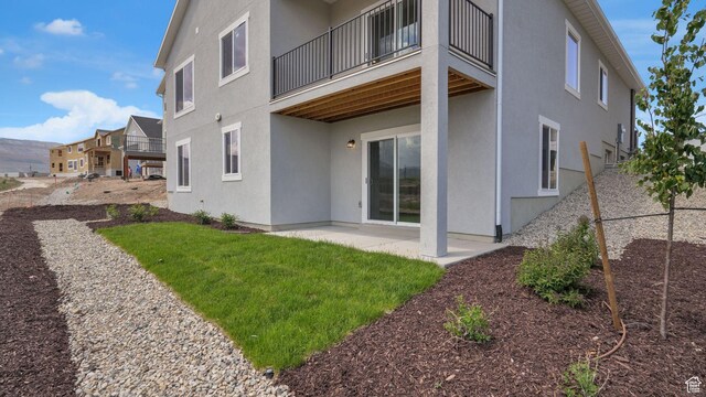 6311 W Butte County Dr S Unit 448, Herriman, UT 84096 - rear view of house featuring stucco siding, a balcony, and a patio area