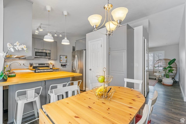 13105 S 2420 W, Riverton, UT 84065 - dining space with dark wood finished floors, a chandelier, and baseboards