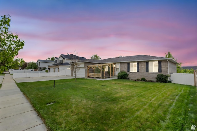 single story home with fence, a lawn, a garage, and brick siding