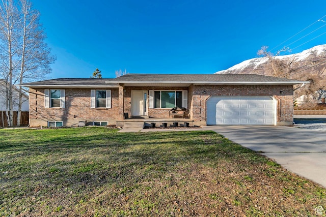 ranch-style home with fence, concrete driveway, a front lawn, a garage, and brick siding