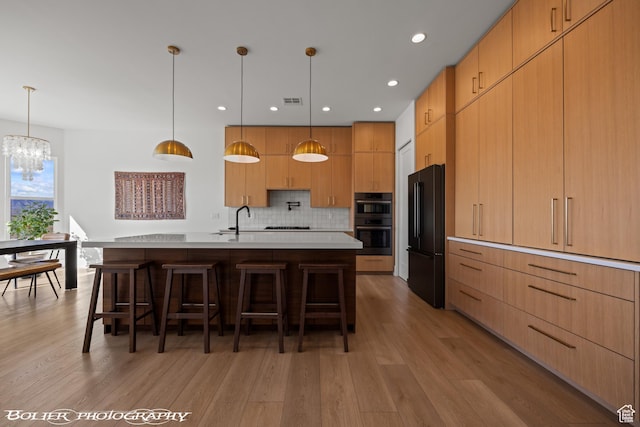 3218 E Rimrunner Dr, St George, UT 84790 - kitchen featuring light countertops, decorative backsplash, a kitchen breakfast bar, a notable chandelier, and black appliances