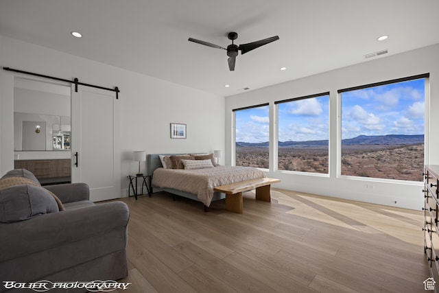 3218 E Rimrunner Dr, St George, UT 84790 - bedroom with visible vents, a barn door, recessed lighting, wood finished floors, and a mountain view