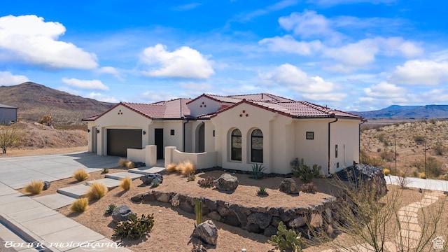 3218 E Rimrunner Dr, St George, UT 84790 - mediterranean / spanish house featuring an attached garage, a tiled roof, concrete driveway, stucco siding, and a mountain view
