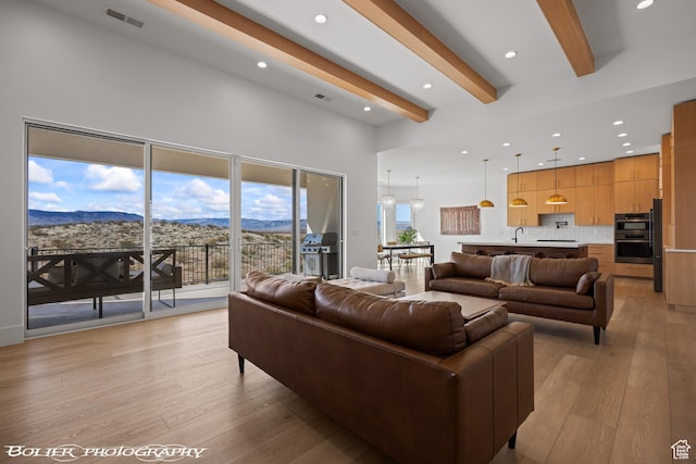 3218 E Rimrunner Dr, St George, UT 84790 - living area with visible vents, light wood-type flooring, a high ceiling, beamed ceiling, and a mountain view