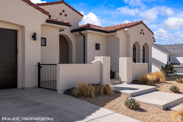3218 E Rimrunner Dr, St George, UT 84790 - view of front of property with a fenced front yard, stucco siding, a tiled roof, and a gate