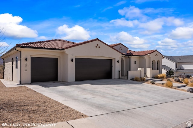 3218 E Rimrunner Dr, St George, UT 84790 - mediterranean / spanish house with a garage, concrete driveway, stucco siding, and a tiled roof