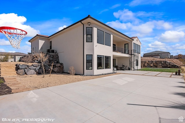3218 E Rimrunner Dr, St George, UT 84790 - back of property with a tiled roof, a patio, stairway, and stucco siding