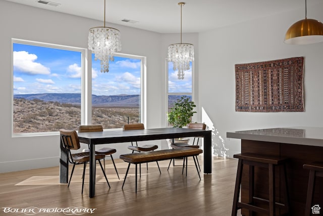 3218 E Rimrunner Dr, St George, UT 84790 - dining area with visible vents, an inviting chandelier, wood finished floors, and a healthy amount of sunlight