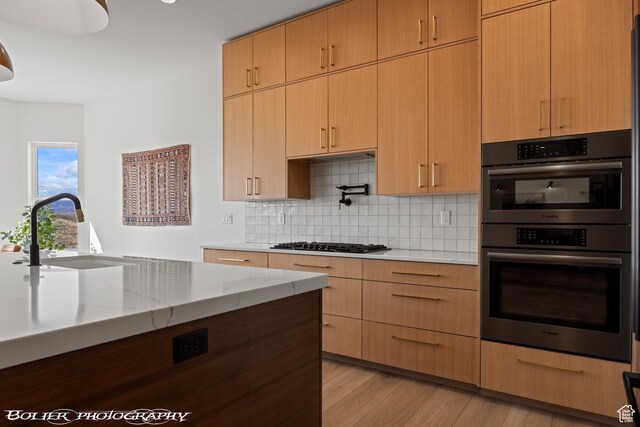 3218 E Rimrunner Dr, St George, UT 84790 - kitchen featuring tasteful backsplash, double oven, light wood-type flooring, gas stovetop, and a sink