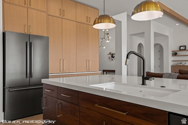 3218 E Rimrunner Dr, St George, UT 84790 - kitchen featuring hanging light fixtures, light stone counters, freestanding refrigerator, arched walkways, and a sink