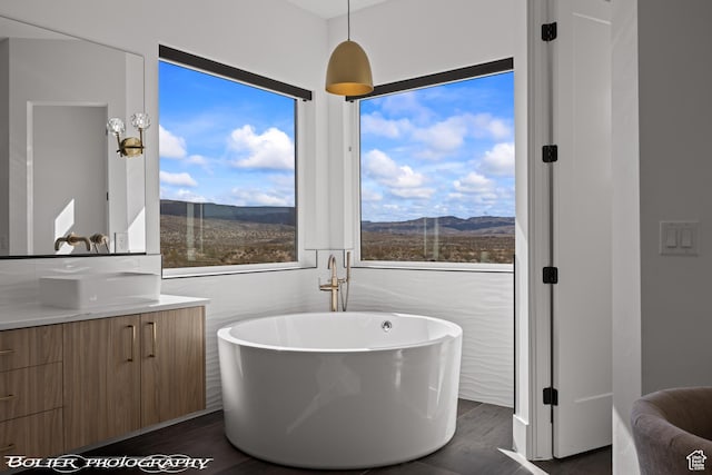 3218 E Rimrunner Dr, St George, UT 84790 - full bath featuring a freestanding tub, a mountain view, a healthy amount of sunlight, and wood finished floors