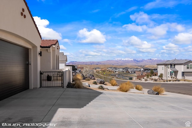 3218 E Rimrunner Dr, St George, UT 84790 - view of patio / terrace with a garage, a gate, a mountain view, and a residential view