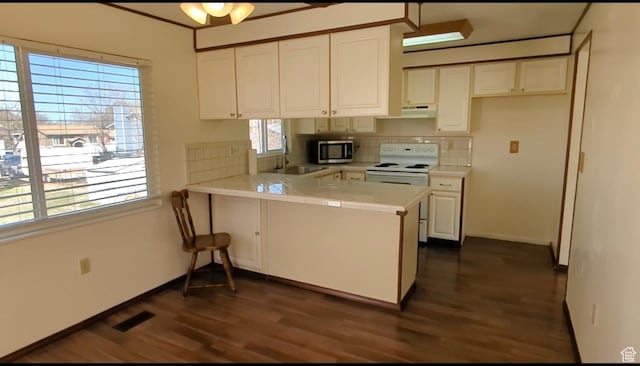 5063 S 2825 W, Roy, UT 84067 - kitchen with a peninsula, white electric stove, stainless steel microwave, under cabinet range hood, and tile countertops