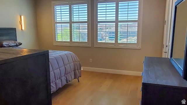 bedroom featuring wood finished floors and baseboards