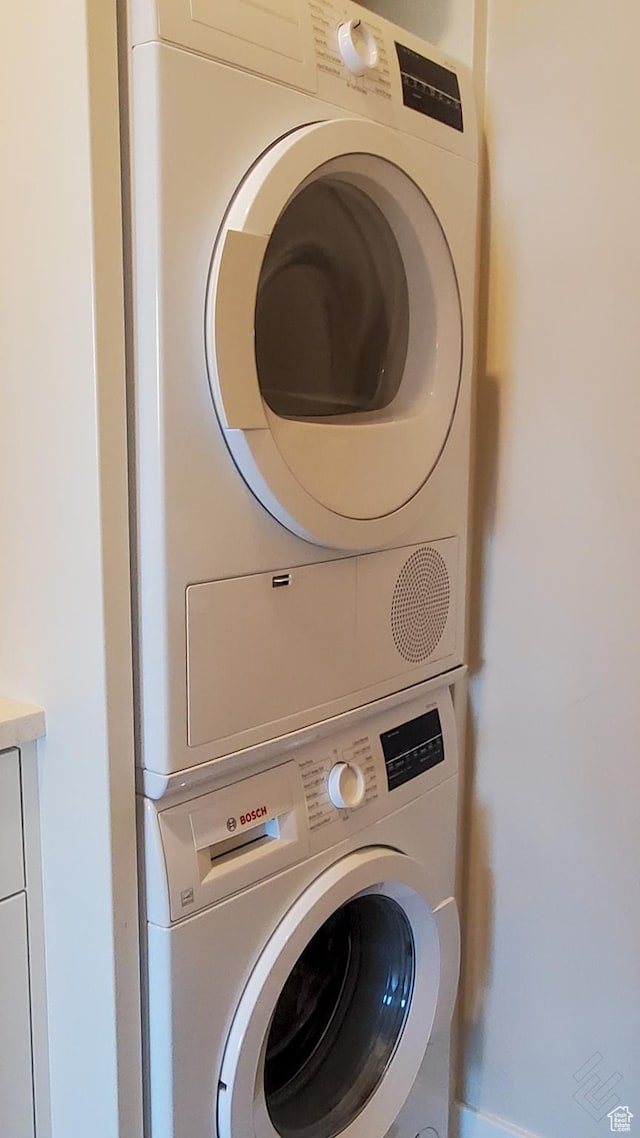clothes washing area featuring laundry area and stacked washer / dryer