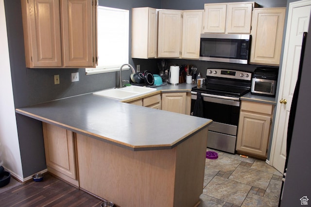 246 W 5000 S, Washington Terrace, UT 84405 - kitchen featuring stone finish floor, a sink, appliances with stainless steel finishes, a breakfast bar area, and a peninsula
