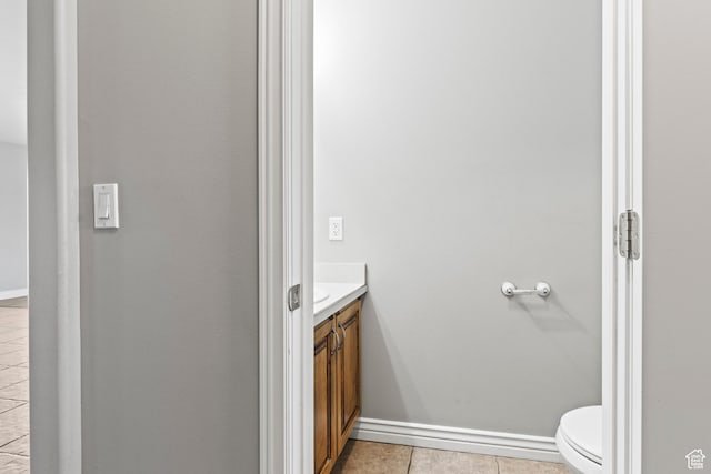 bathroom with tile patterned flooring, toilet, vanity, and baseboards