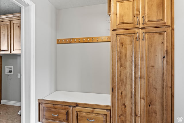 mudroom with a textured ceiling and baseboards