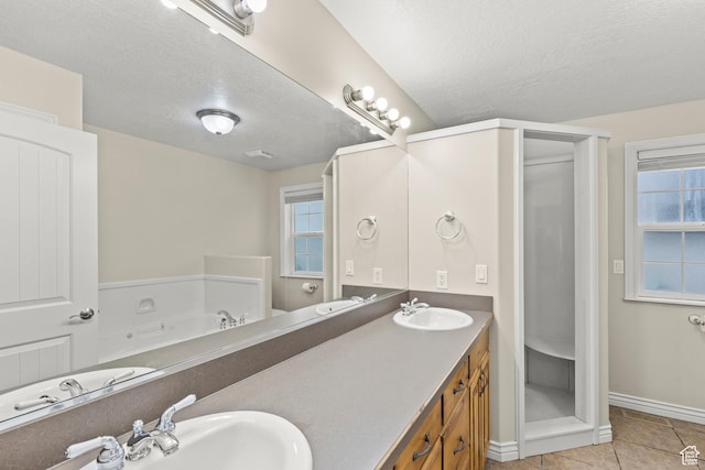 bathroom featuring a textured ceiling, a wealth of natural light, and a sink