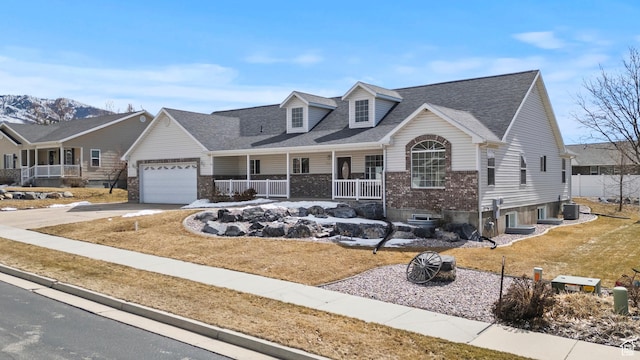 view of front facade featuring brick siding, a porch, concrete driveway, and a garage