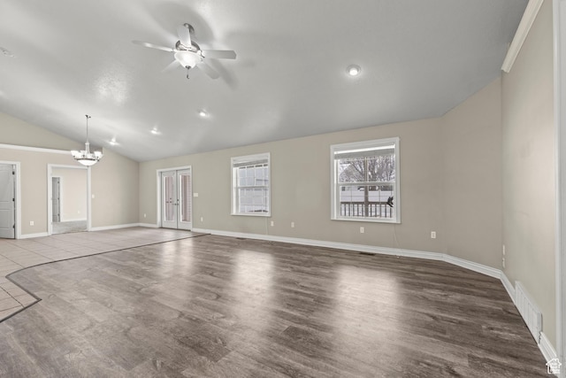 unfurnished living room featuring visible vents, baseboards, vaulted ceiling, ceiling fan with notable chandelier, and wood finished floors