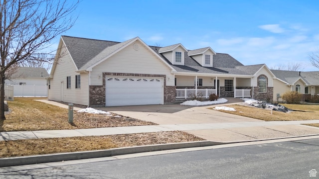 view of front of home with driveway, roof with shingles, an attached garage, covered porch, and brick siding