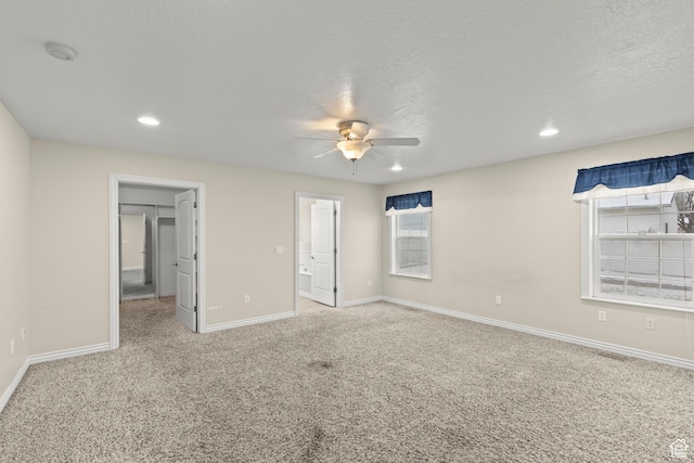 unfurnished bedroom featuring a spacious closet, recessed lighting, carpet, and baseboards