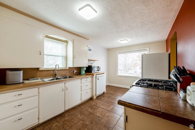 2348 Iowa Ave, Ogden, UT 84401 - kitchen featuring a sink, white appliances, a wealth of natural light, and white cabinets