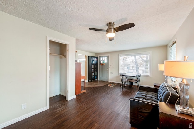 2348 Iowa Ave, Ogden, UT 84401 - living room featuring a textured ceiling, arched walkways, baseboards, ceiling fan, and dark wood-style flooring