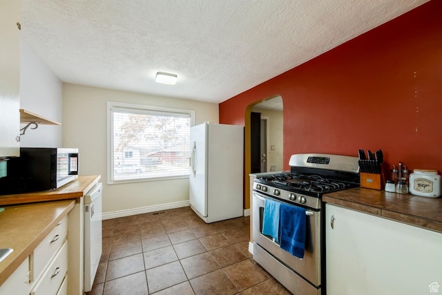 2348 Iowa Ave, Ogden, UT 84401 - kitchen featuring white appliances, arched walkways, white cabinets, a textured ceiling, and tile patterned floors