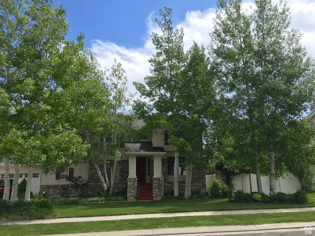 8377 S Wild Oak Dr, West Jordan, UT 84088 - view of front facade featuring an attached garage, stucco siding, a front lawn, stone siding, and brick siding