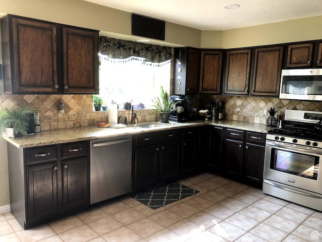 8377 S Wild Oak Dr, West Jordan, UT 84088 - kitchen with decorative backsplash, light stone countertops, appliances with stainless steel finishes, and a sink