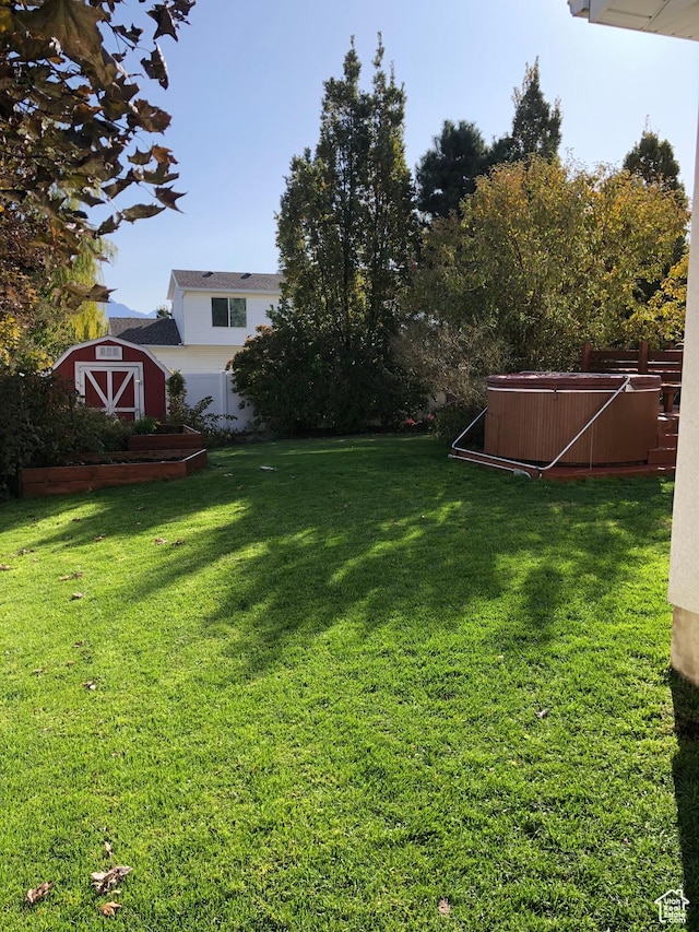 8377 S Wild Oak Dr, West Jordan, UT 84088 - view of yard featuring a storage unit, an outdoor structure, and a hot tub